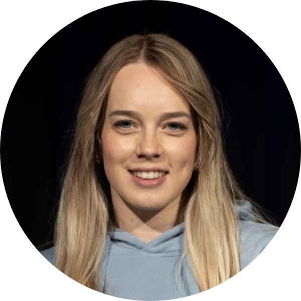 Rundes Portrait einer Hip-Hop-Trainerin mit blonden Haaren und hellblauem Hoodie vor dunklem Hintergrund.