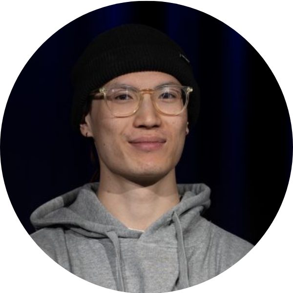 Portrait von Duy, Breakdance-Trainer bei KayJay’s in München, schwarze Beanie und Brille vor dunklem Hintergrund.