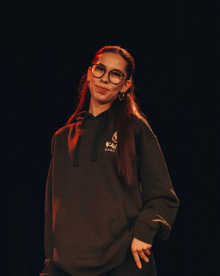 Eli, Trainerin bei KayJays, mit Brille im braunen KayJays-Hoodie